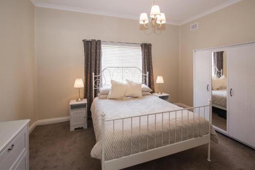 巴瑟尔顿海拉维耶间度假屋的白色的卧室设有床和窗户