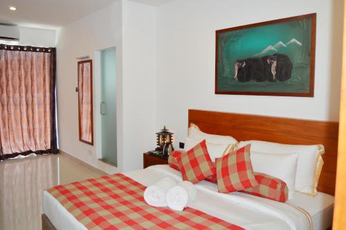 平纳瓦拉Cafe Pinnalanda的一间卧室配有红色和白色枕头的床
