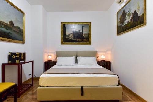 罗马Elite Rome Apartments的卧室配有一张床,墙上挂有两幅画
