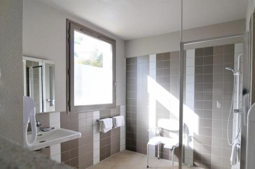 Avignonet-de-LauragaisRelais Fasthotel Port Lauragais的一间带水槽和淋浴及窗户的浴室