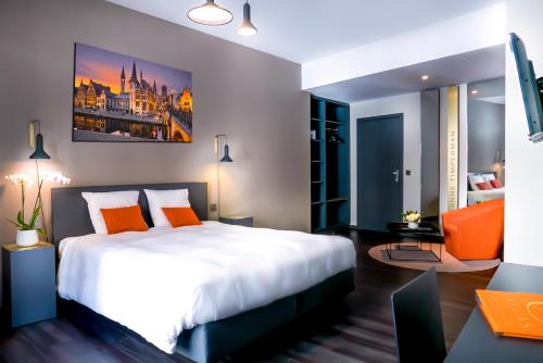 布鲁塞尔布鲁塞尔阿特拉斯酒店的卧室配有白色大床和橙色椅子