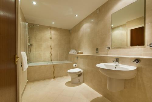 威廉堡斯特隆罗斯特旅馆的浴室配有盥洗盆、卫生间和浴缸。