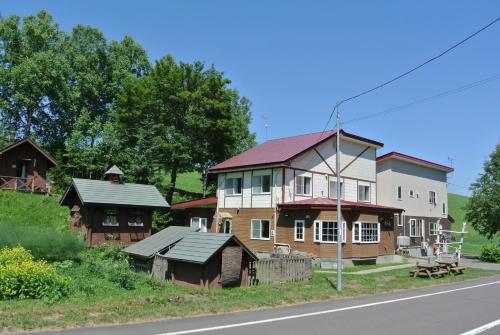 美瑛町惠雪笑颜绽放住宿加早餐旅馆的路边的大房子