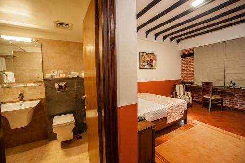 加德满都Traditional Comfort Boutique Hotel的客房设有带一张床和盥洗盆的浴室