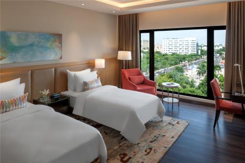 钦奈羽毛钦奈拉达酒店的酒店客房配有两张床和一张书桌
