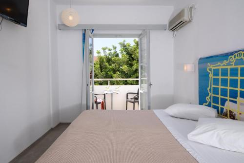 卡马利RK海滩酒店的一间卧室设有一张床和一个大窗户