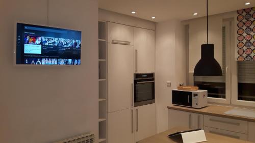 萨格勒布Apartment Sarita的带微波炉的厨房和墙上的电视