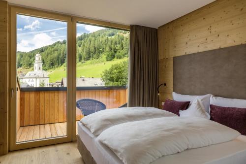 塞斯托Hotel Strobl的一间卧室设有一张大床和一个大窗户