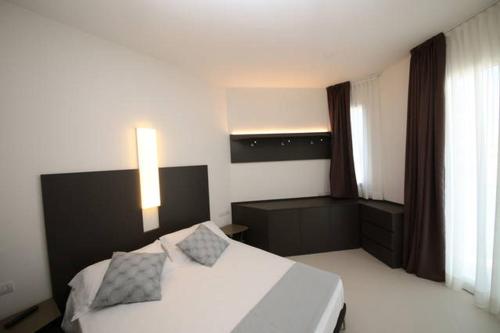 西尼加利亚Residence Cristallo Senigallia的卧室配有白色的床和两个枕头