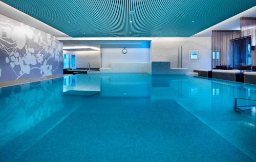 圣莫里茨格堤诺山酒店的大楼内一个蓝色的大型游泳池