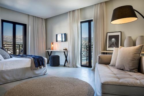 阿尔戈斯托利翁凯法利尼亚格兰德酒店的一间卧室配有一张床、一张沙发和窗户。