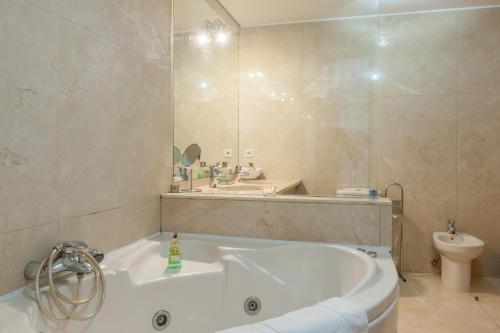 波尔图Bartolomeu Beach Apartments的带浴缸、盥洗盆和卫生间的浴室