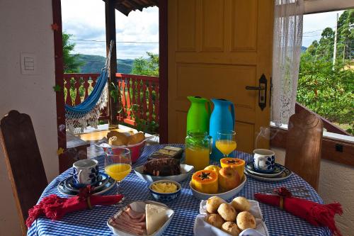拉夫拉斯诺瓦斯Vila das Artes Chales的一张桌子,上面有蓝色的桌布,上面有食物和饮料