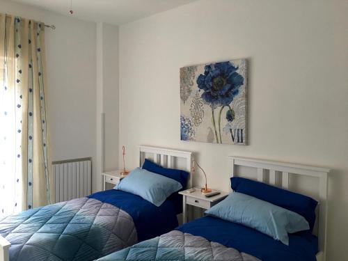 塔兰托Hibiscus的一间卧室设有两张床,墙上挂着一幅画
