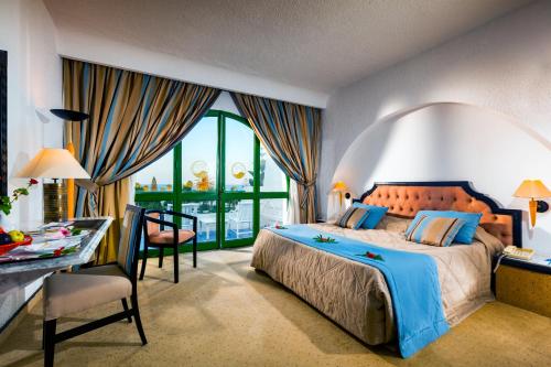 甘达坞伊港康大维港哈斯朱拔撒拉萨温泉酒店的酒店客房配有一张床、一张桌子和一张桌子以及椅子。