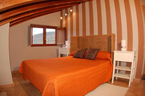 TerminónCasa Rural El Esquilador的一间卧室配有一张带橙色毯子的床