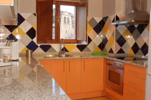 TerminónCasa Rural El Esquilador的厨房配有橙色橱柜、水槽和窗户。
