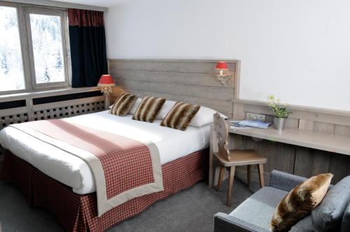 阿克 1600阿卡蒂安酒店的一间卧室配有一张床和一张桌子及椅子
