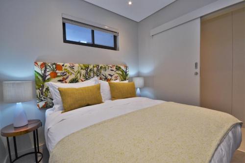 巴利托418 Zimbali Suites的一间卧室配有一张带黄色枕头的大床