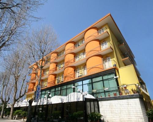 里米尼苏西酒店的街道上一座黄色和橙色的大建筑