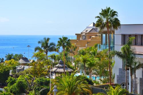 阿德耶尼瓦利亚花园酒店的享有棕榈树度假村和大海的景致。
