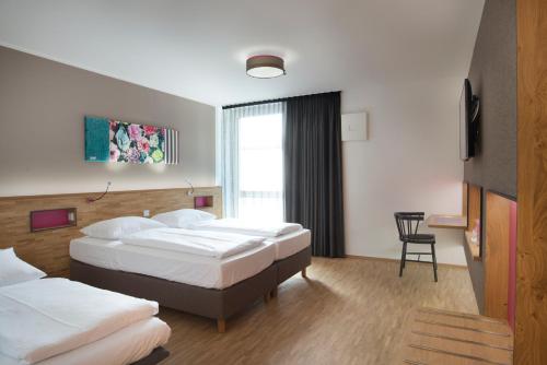 慕尼黑法布酒店的酒店客房,配有两张床和椅子
