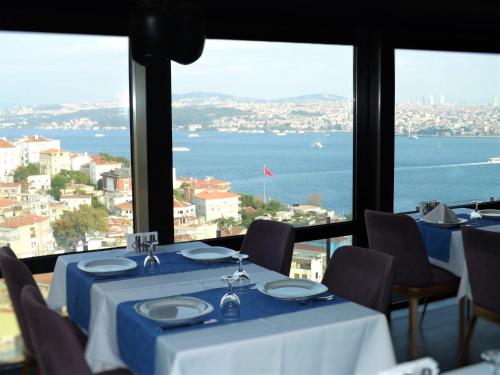 伊斯坦布尔吉汉吉尔酒店的一间带桌椅并享有水景的餐厅