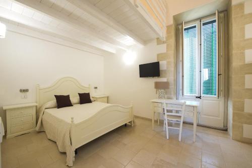 朱尔迪尼亚诺Palazzo Vilei的一间卧室配有一张床、一张书桌和一台电视