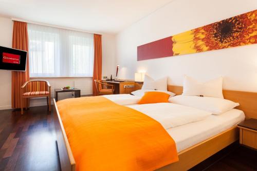 布雷根茨德国酒店的酒店客房设有一张大床和一台电视机。