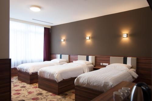 阿姆斯特丹金斯考特酒店的配有白色床单的酒店客房内的两张床