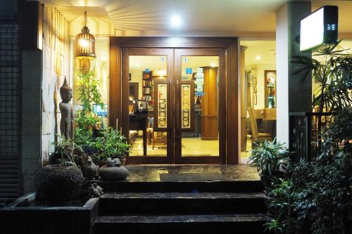 曼谷素坤逸班18号酒店的一座种植盆栽植物的建筑的前门