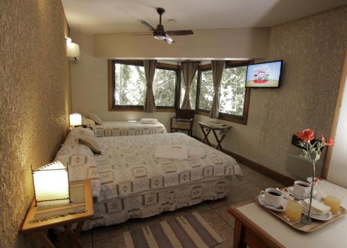 门多萨Hotel Xumec Mendoza的一间卧室配有两张床和一台平面电视