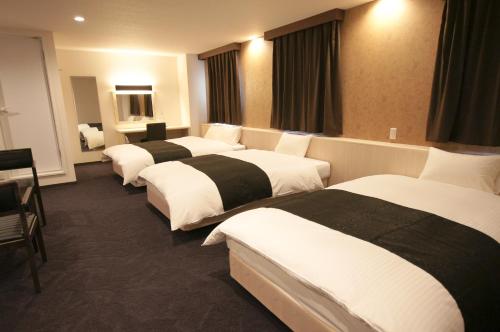宫崎宫崎第一酒店的一间酒店客房,房间内设有四张床