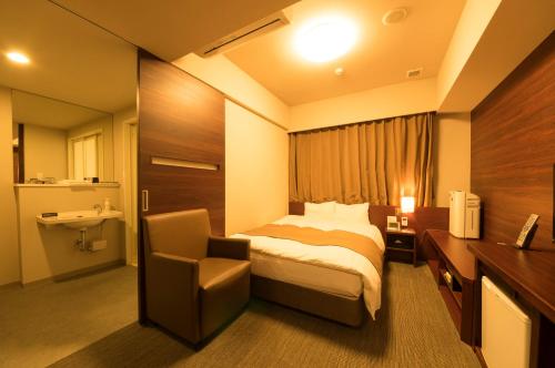 姬路多美迎姫路酒店的配有一张床和一把椅子的酒店客房