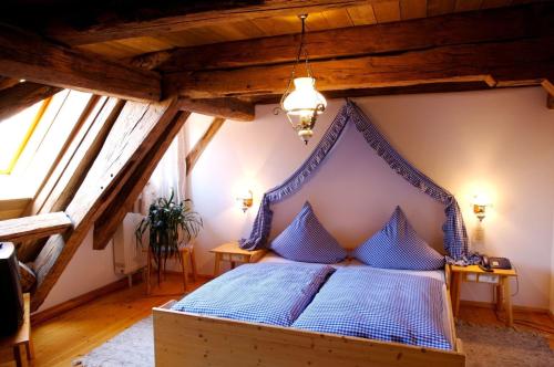 Tauberzell祖姆法尔肯兰德豪斯酒店的阁楼卧室配有蓝色床
