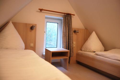 维特Doppelhaushälfte in Vitte auf Hiddensee的小房间设有两张床和窗户