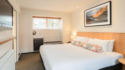 福克斯冰川西岸冰河福克斯酒店的卧室配有白色的床和窗户。