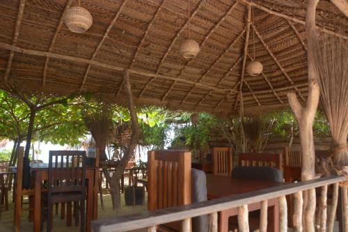 坦加拉朱砂豪华帐篷度假酒店的屋顶下设有桌椅的餐厅