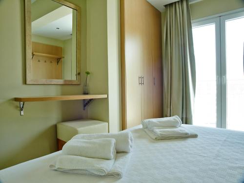 瓦西利基Cosmos Apartments的一间卧室,在床上配有两张毛巾和镜子