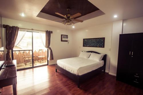长滩岛绿洲度假酒店的一间卧室配有一张床和吊扇