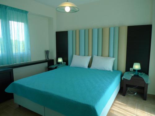 沃尔沃罗Excellent Villa的一间卧室配有一张蓝色的床和两盏灯。