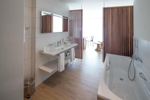 胡尔登罗斯里胡尔登酒店的浴室配有盥洗盆和浴缸。