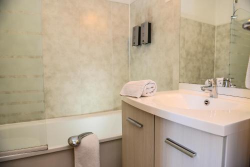 GanLogis Hostellerie du Neez的浴室配有盥洗盆、镜子和浴缸