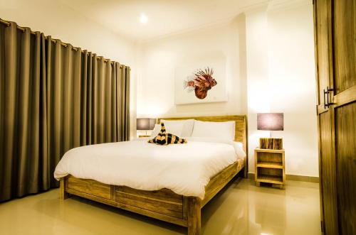 吉利特拉旺安Blue Marlin Dive Resort Trawangan的一间卧室配有大床和窗帘
