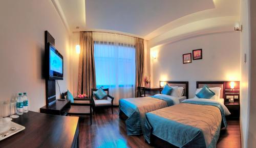 阿格拉休闲酒店的酒店客房设有两张床和一台平面电视。