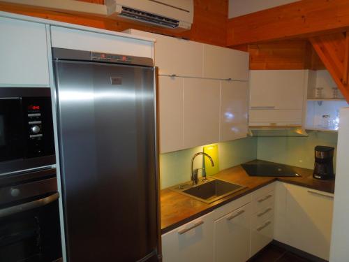塔库沃里Aaria Apartment的厨房配有不锈钢冰箱和水槽