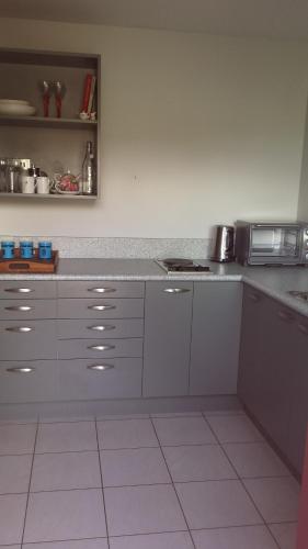 波里鲁阿Ocean View Self-contained Apartment的厨房配有白色橱柜和台面