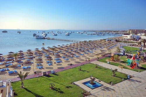 赫尔格达Pickalbatros White Beach Resort - Hurghada的海滩上放着一把遮阳伞和水