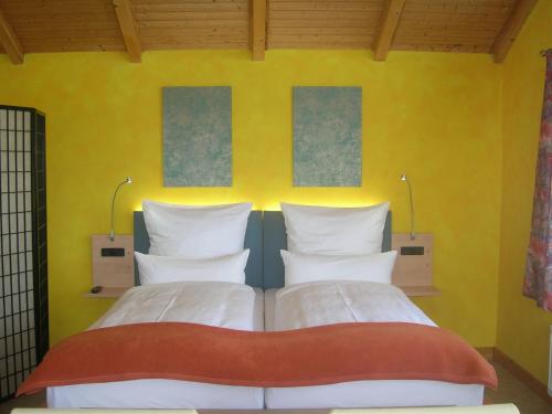 Andělská Hora卡萨安德尔卡旅馆的一间卧室设有两张床和黄色的墙壁