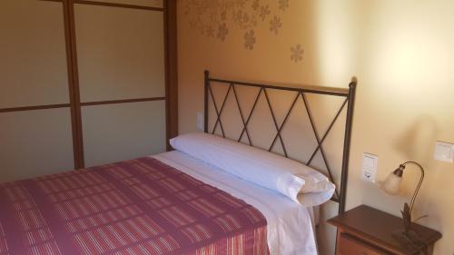 阿尔克萨尔Casa Sampietro的一间卧室配有一张带红色毯子的床